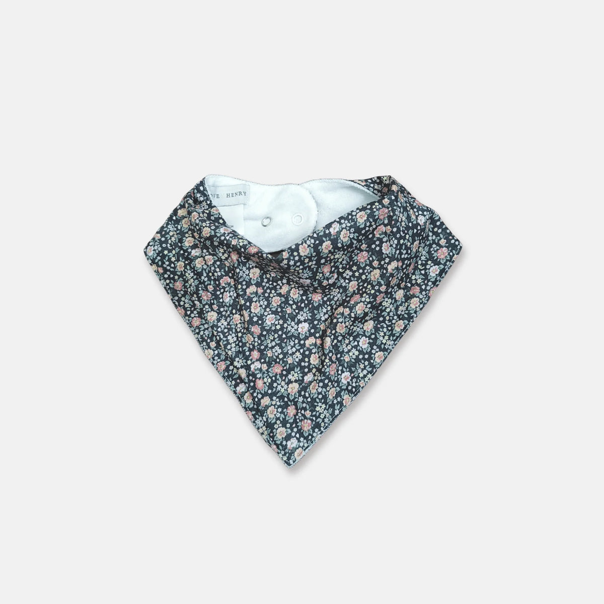 A triangular baby bandana bib with a dense small floral print in pink, purple, and white on a dark navy background, featuring a light blue inner lining.