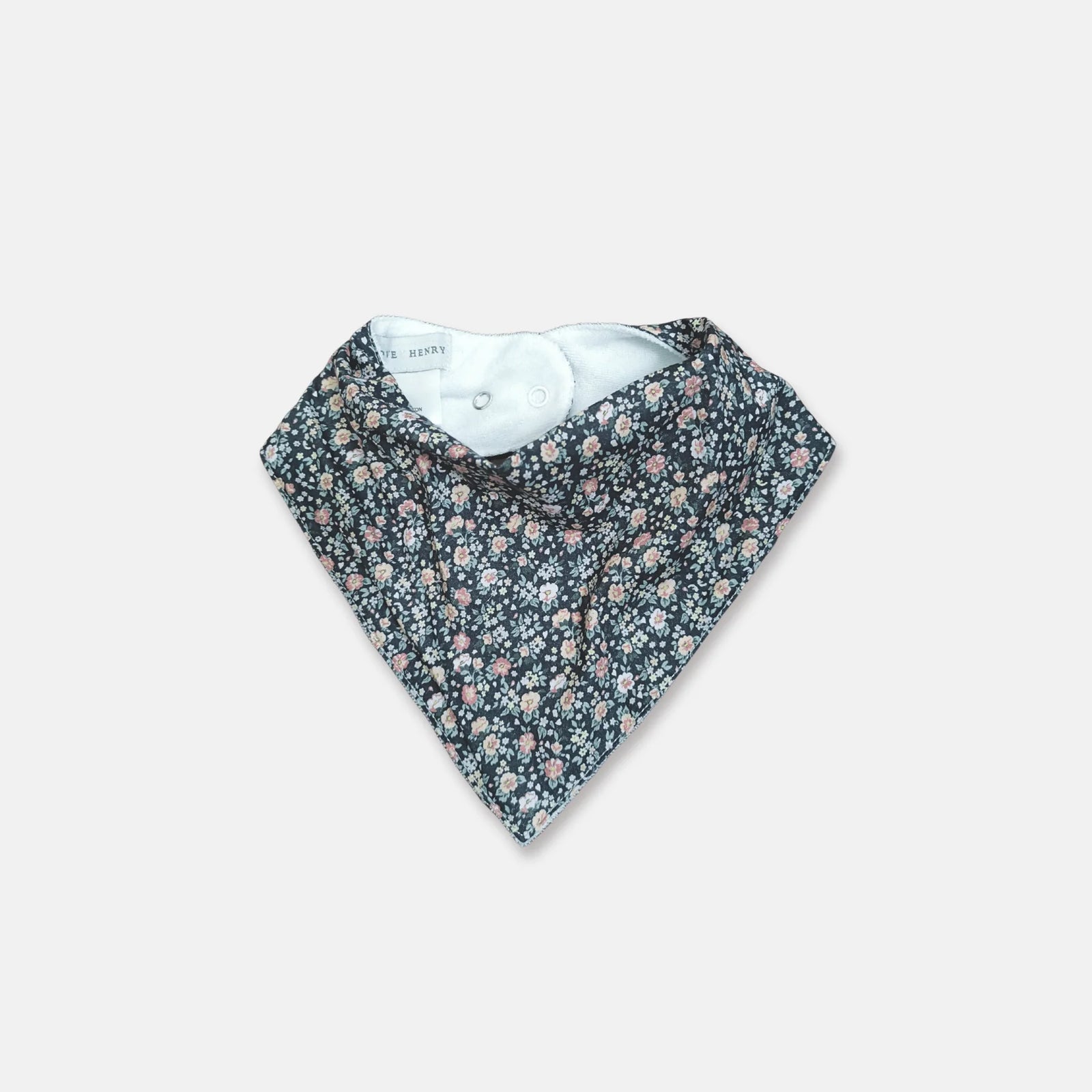 A triangular baby bandana bib with a dense small floral print in pink, purple, and white on a dark navy background, featuring a light blue inner lining.