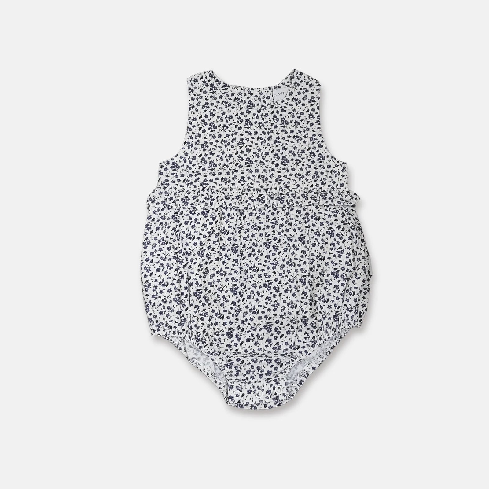 A sleeveless baby romper with a white base and a dense navy blue floral print, shown flat against a light gray background.