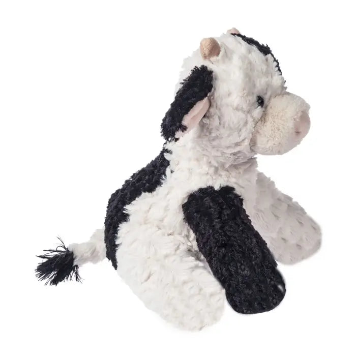 Plush cow toy with black and white pattern on a white background