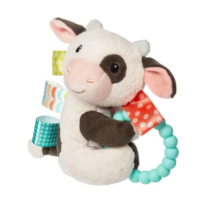 Plush cow toy with a teething ring on a white background