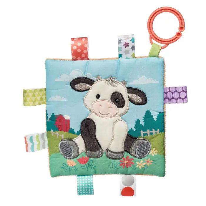 Children's soft toy with a cow design on a blue background