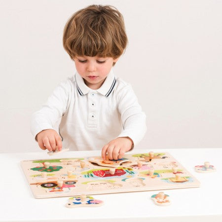 FSC Large Peg Puzzle Farm. Child playing with a wooden puzzle on a white surface