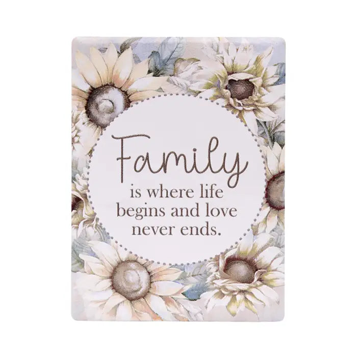 A rectangular decorative sign with rounded corners featuring watercolor-style sunflowers around a central white oval. The sign reads, 'Family is where life begins and love never ends.
