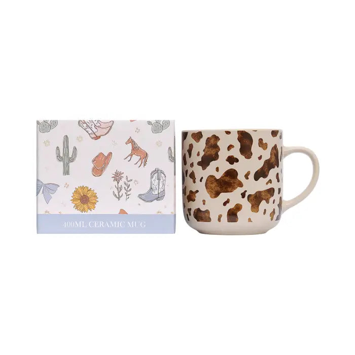 A 100ml ceramic mug with a brown and beige cow print pattern, shown next to its illustrated gift box featuring western-themed designs like a cactus, cowboy boots, and a sunflower.