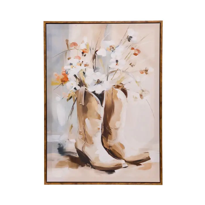 Framed wall art featuring a still-life painting of tan cowboy boots filled with white, orange, and cream flowers, shown against a light neutral background.