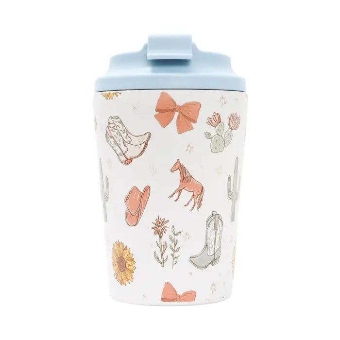 A white insulated travel tumbler with a light blue lid, decorated with a western-themed pattern of cowboy boots, a horse, cacti, flowers, and bows.
