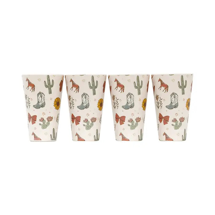 Four small tapered cups with a western-themed print featuring cacti, boots, horseshoes, and cowboy hats on a cream background, shown against a plain white background.