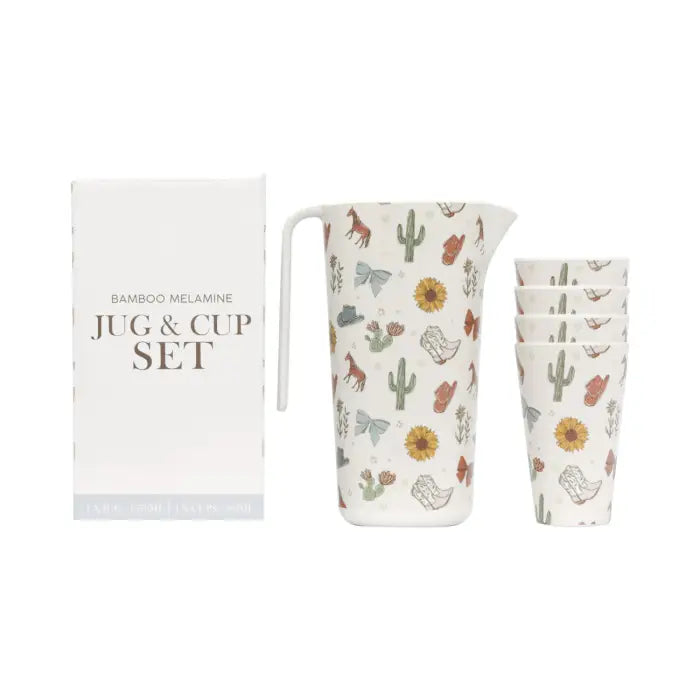 An off-white ceramic pitcher with a western-themed print featuring cowboy boots, cacti, sunflowers, horseshoes, and horses.