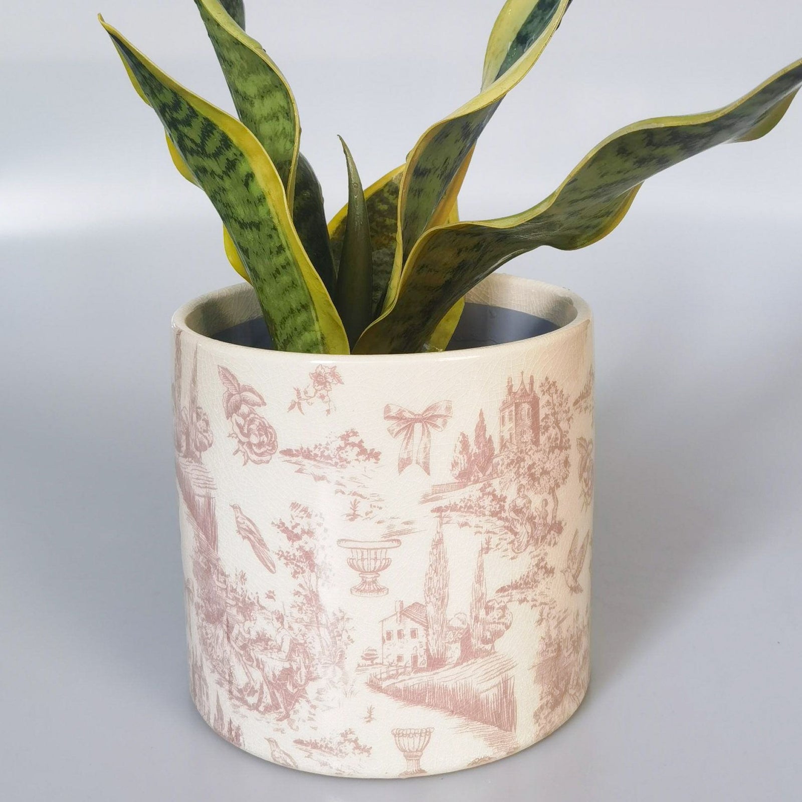 Decorative pot with toile de Jouy pattern on a white background