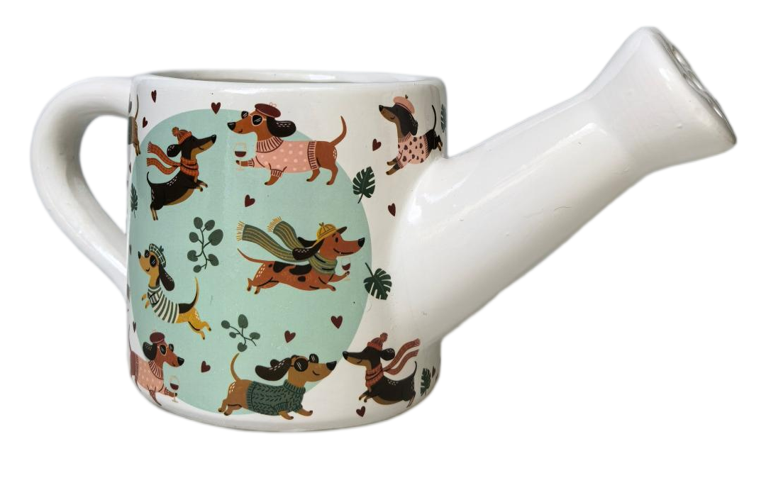 A white ceramic watering can with a handle and spout, decorated on the front with a light blue oval panel featuring various dachshund illustrations in different poses.