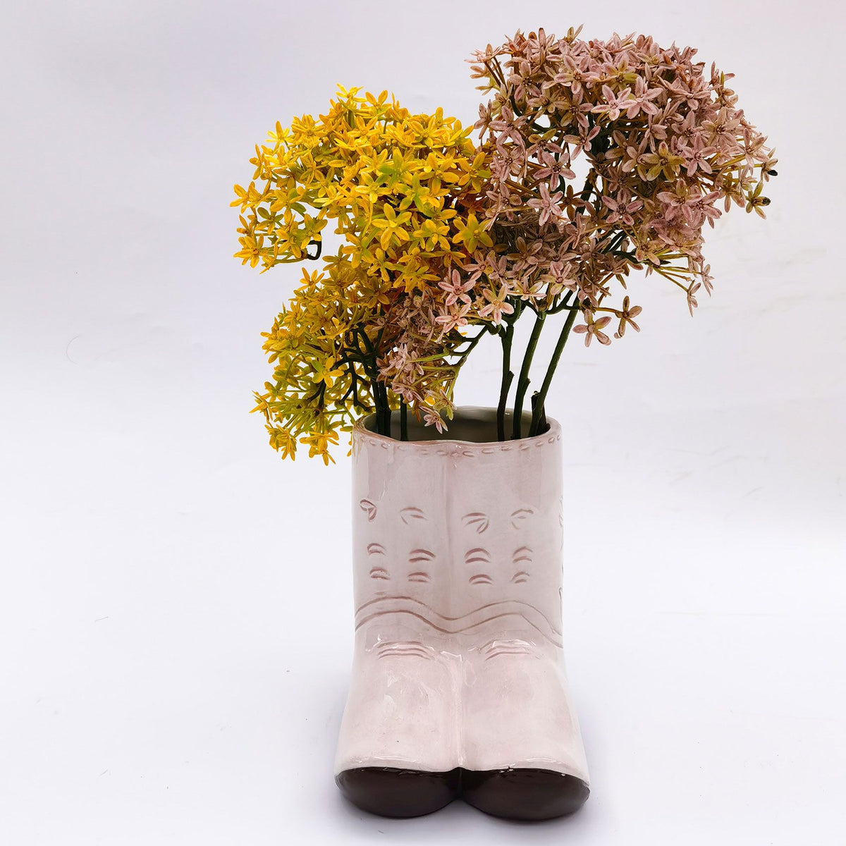 Urban Products 16cm Pink Cowboy Boots Planter. Pink ceramic boot with yellow and pink flowers on a white background