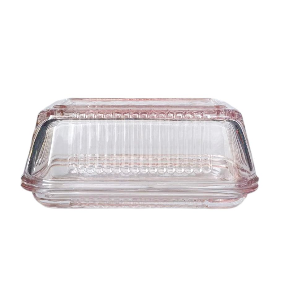 Clear glass butter dish with pink rim on a white background