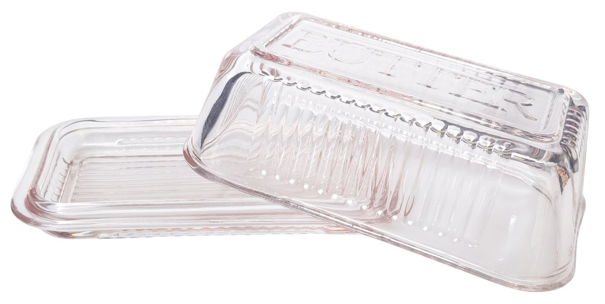 Clear glass butter dish with lid on a white background